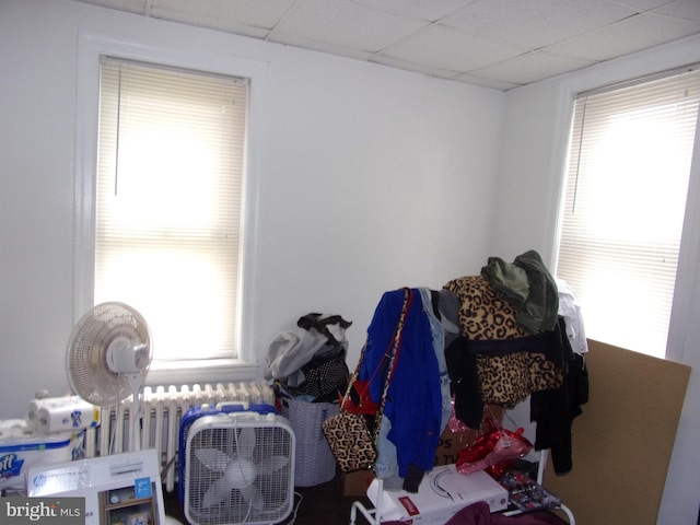 bedroom featuring a drop ceiling and multiple windows