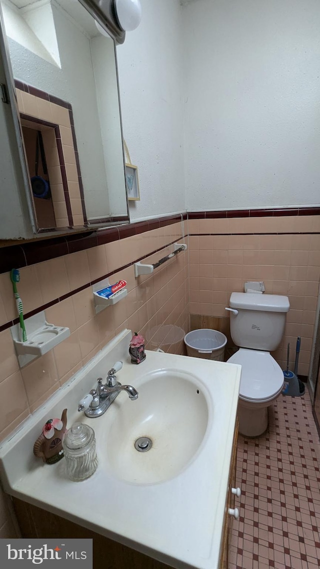 bathroom with vanity, tile walls, and toilet