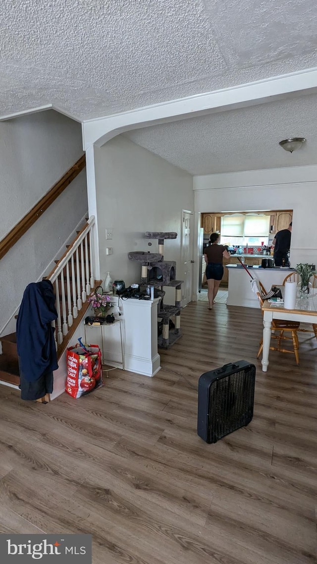 living room with a textured ceiling and hardwood / wood-style floors