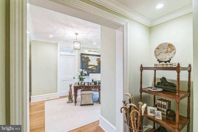 hall with an inviting chandelier, hardwood / wood-style flooring, and crown molding