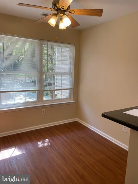 unfurnished room featuring dark hardwood / wood-style floors and ceiling fan