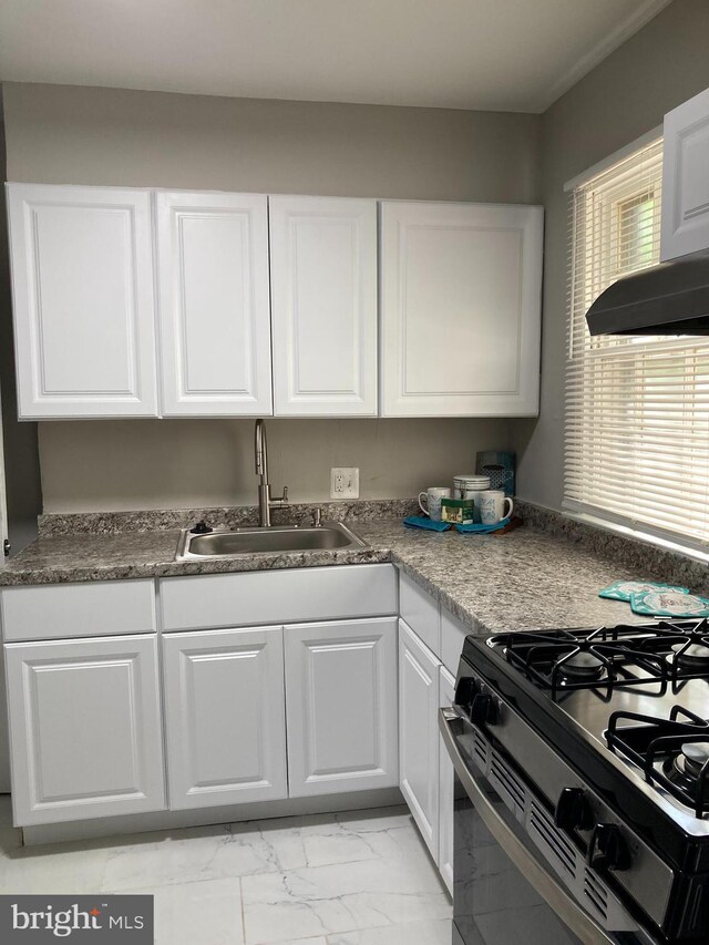 kitchen with white cabinets, gas range, sink, and exhaust hood