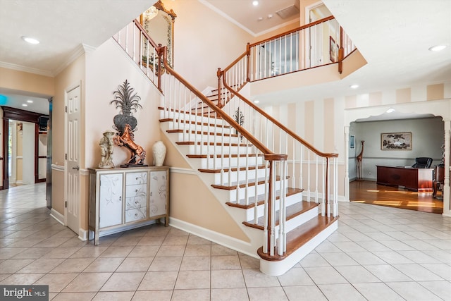 stairway with crown molding and tile patterned flooring