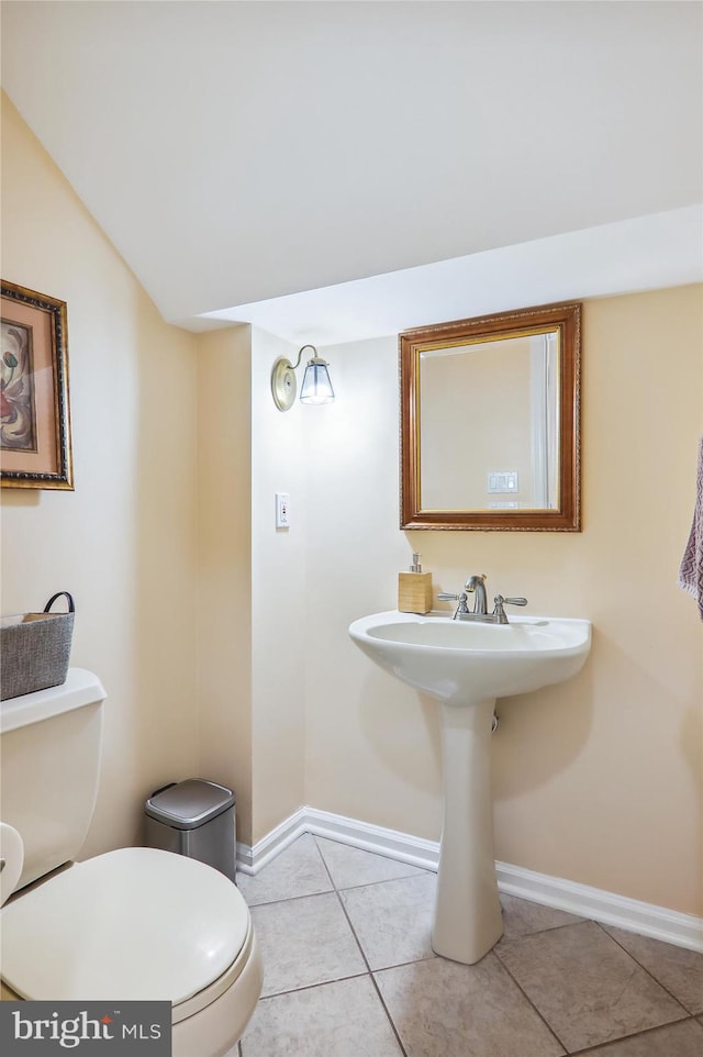 bathroom featuring vaulted ceiling, tile patterned flooring, toilet, and sink