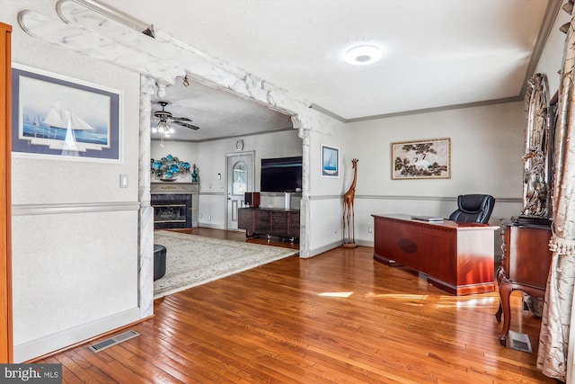 office area with wood-type flooring, ornamental molding, and ceiling fan