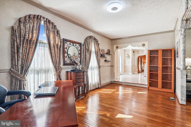 entryway with hardwood / wood-style flooring, crown molding, and a textured ceiling