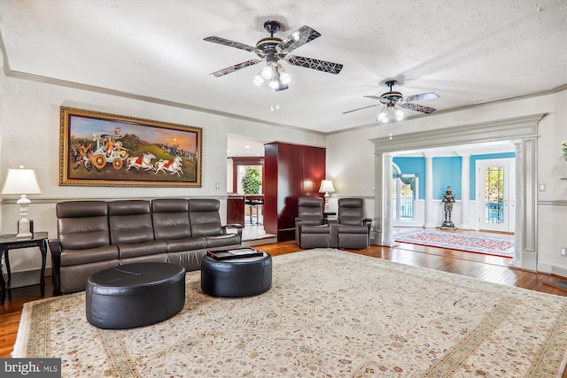 living room with wood-type flooring, a wealth of natural light, and ceiling fan