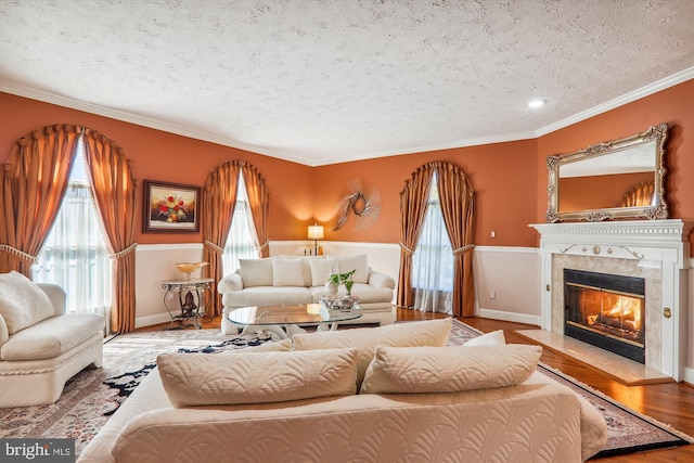 living room featuring ornamental molding, a textured ceiling, and light hardwood / wood-style floors