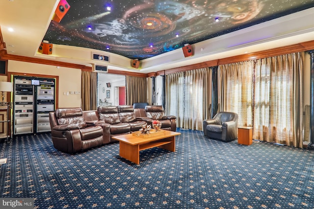 carpeted home theater with a raised ceiling and crown molding