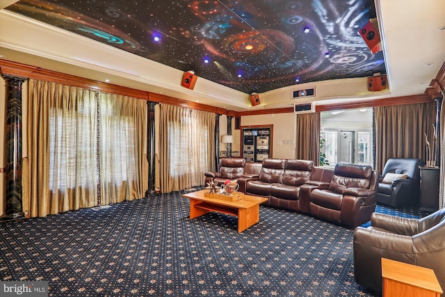 carpeted home theater room featuring a raised ceiling and crown molding