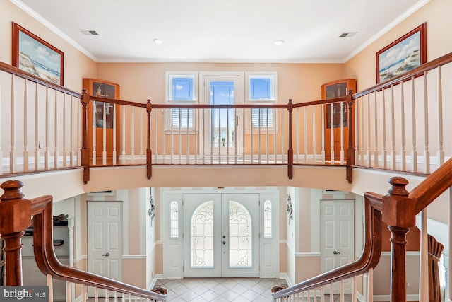 foyer featuring ornamental molding, a healthy amount of sunlight, and french doors