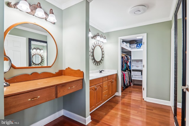 bathroom featuring wood-type flooring, ornamental molding, and vanity