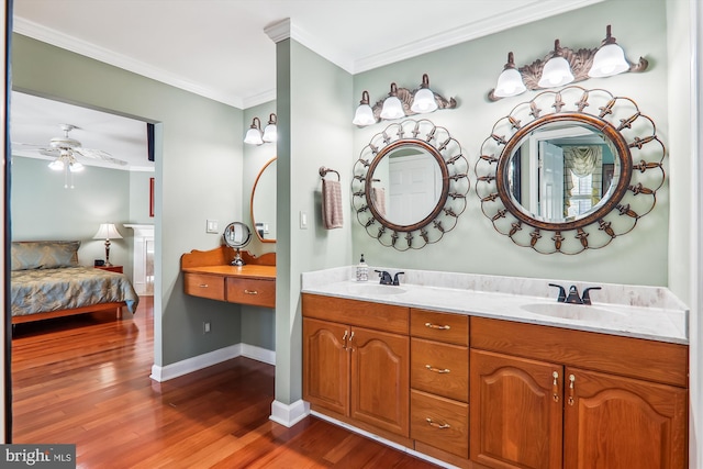 bathroom with wood-type flooring, ornamental molding, vanity, and ceiling fan