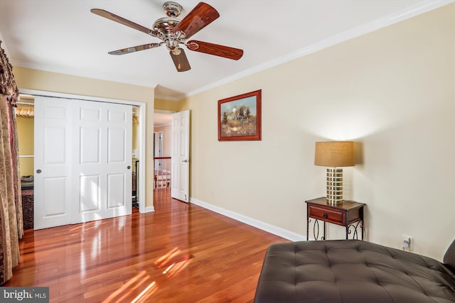 bedroom featuring a closet, hardwood / wood-style flooring, ornamental molding, and ceiling fan