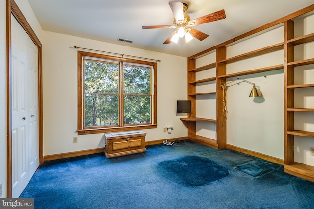 interior space featuring dark carpet and ceiling fan