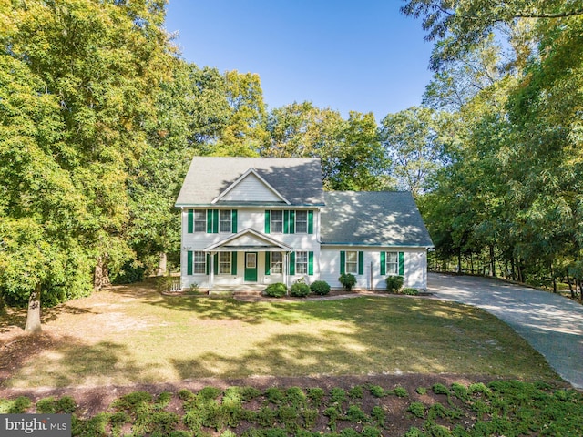 colonial house featuring a front yard and covered porch