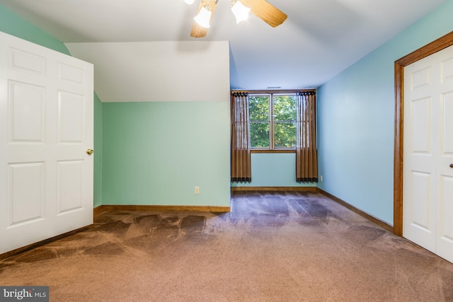 unfurnished bedroom featuring lofted ceiling, ceiling fan, and dark carpet