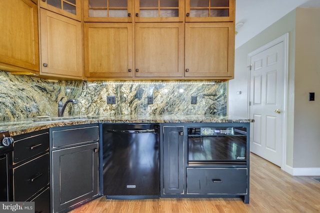 kitchen with tasteful backsplash, black dishwasher, light hardwood / wood-style flooring, sink, and light stone countertops