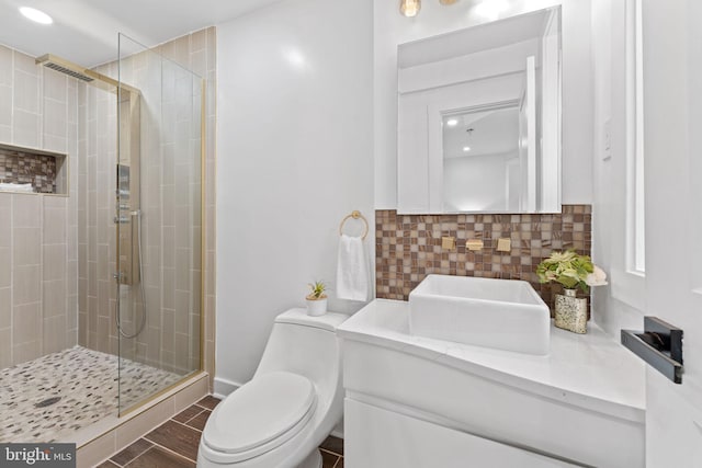 bathroom featuring walk in shower, vanity, toilet, and decorative backsplash