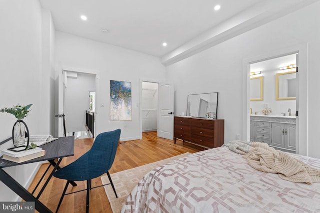 bedroom with light hardwood / wood-style flooring and ensuite bathroom