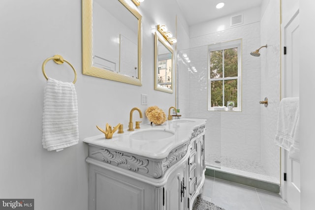 bathroom featuring tiled shower, vanity, and tile patterned floors