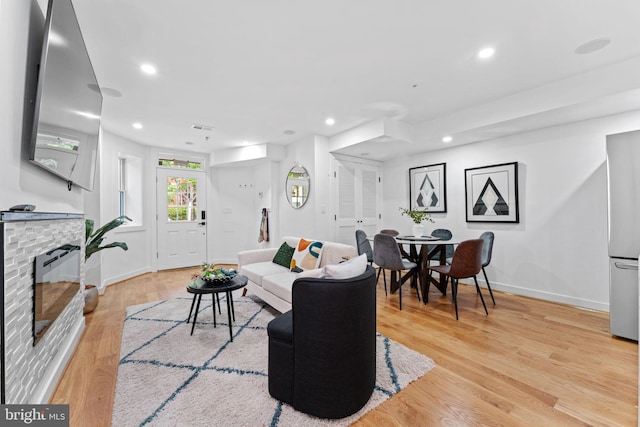 living room featuring a fireplace and light wood-type flooring