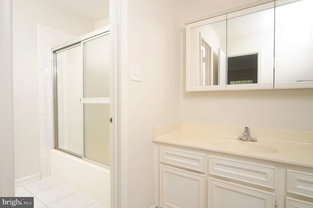 bathroom with tile patterned flooring, vanity, and bath / shower combo with glass door