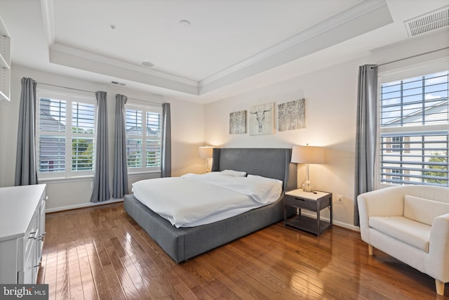 bedroom featuring ornamental molding, a tray ceiling, and hardwood / wood-style floors