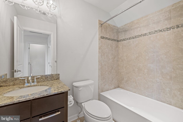 full bathroom with tiled shower / bath, vanity, and toilet