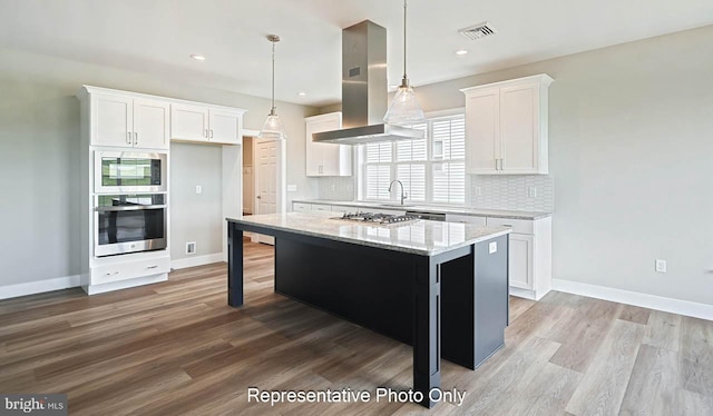 kitchen featuring a center island, white cabinets, tasteful backsplash, island range hood, and stainless steel appliances