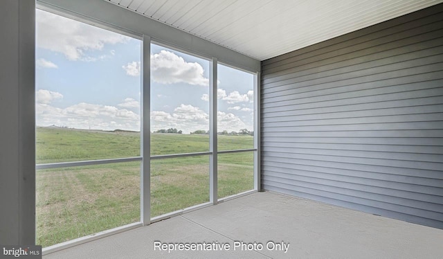 unfurnished sunroom with a rural view and a healthy amount of sunlight