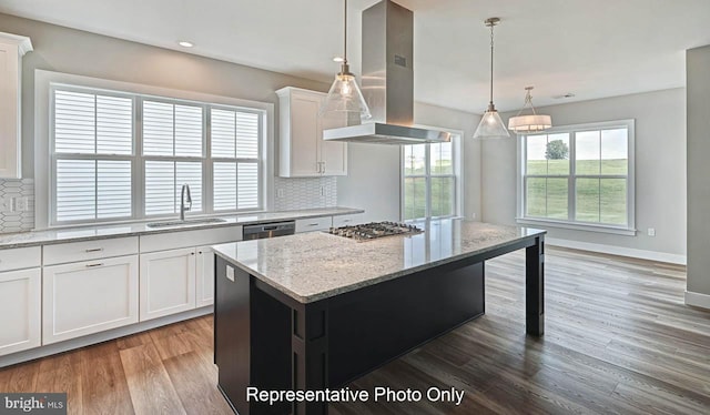 kitchen with decorative backsplash, a center island, white cabinetry, and island exhaust hood