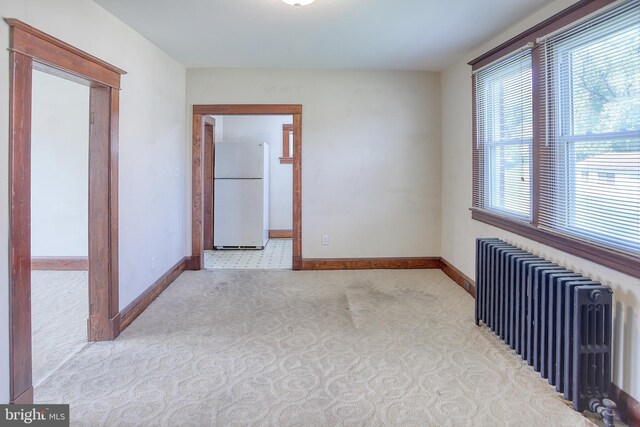 empty room with radiator heating unit and light carpet