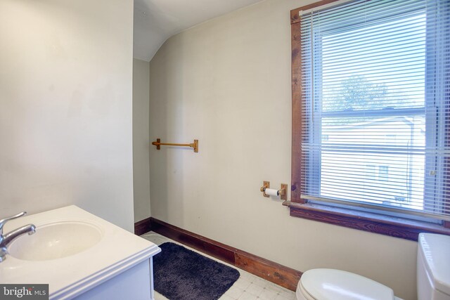 bathroom featuring lofted ceiling, toilet, and vanity