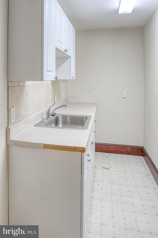 kitchen featuring sink, decorative backsplash, and white cabinets