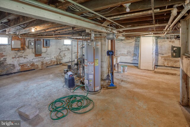 basement with gas water heater, electric panel, and plenty of natural light