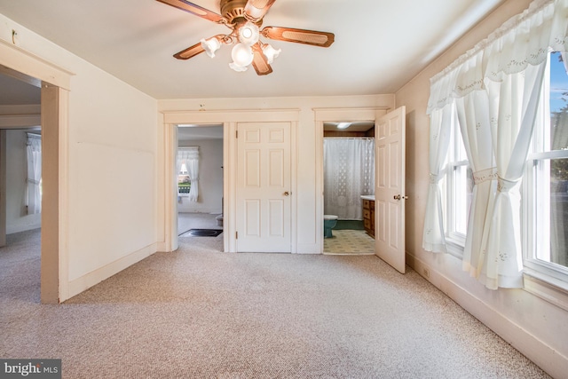 unfurnished bedroom with ensuite bath, ceiling fan, and carpet floors