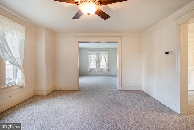 carpeted empty room featuring a healthy amount of sunlight and ceiling fan