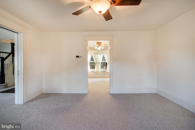 carpeted spare room with ceiling fan