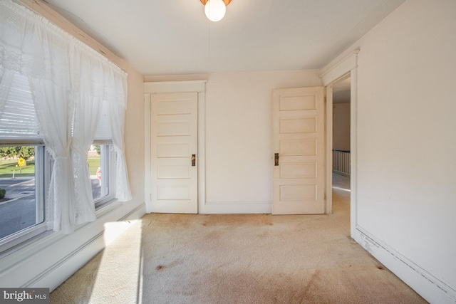 interior space with a baseboard radiator and light carpet