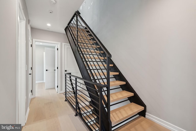 staircase with hardwood / wood-style floors