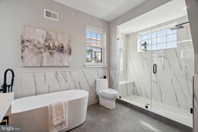 full bathroom featuring plus walk in shower, tile walls, tile patterned floors, vanity, and toilet