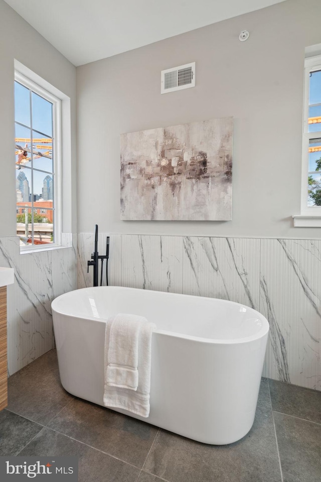 bathroom with tile patterned floors and a bathtub