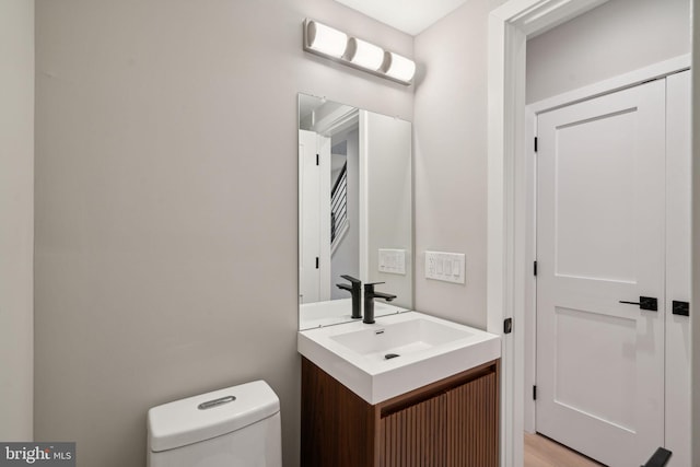 bathroom with vanity, hardwood / wood-style floors, and toilet