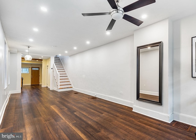 unfurnished living room featuring dark hardwood / wood-style flooring and ceiling fan