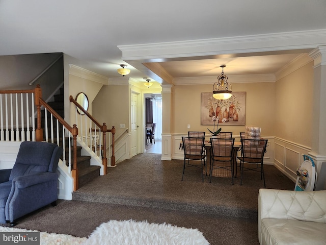 dining room with ornate columns, crown molding, and dark colored carpet