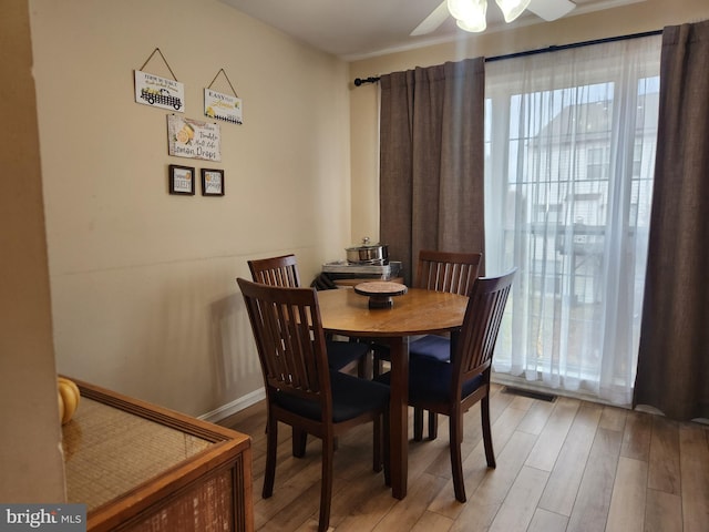 dining area with ceiling fan and light hardwood / wood-style flooring