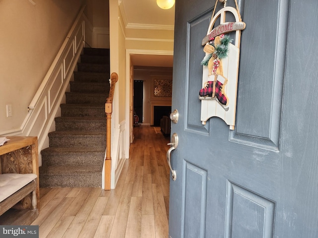 foyer with crown molding and hardwood / wood-style floors