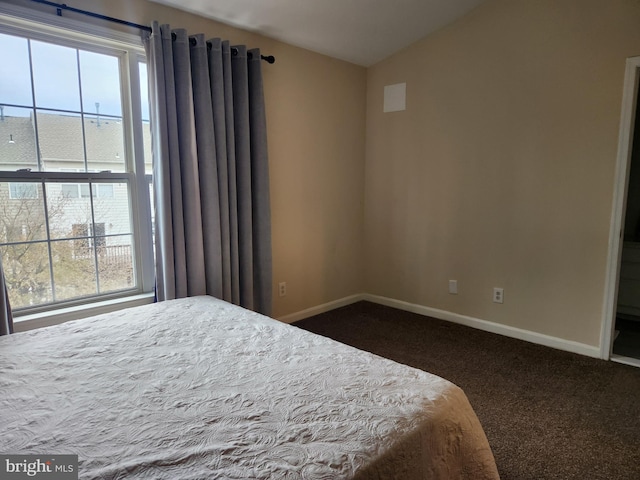 bedroom with dark carpet and lofted ceiling