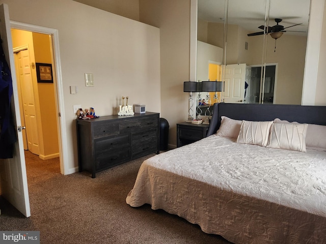 carpeted bedroom with ceiling fan and high vaulted ceiling